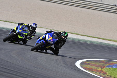close-up photo of people riding motorcycle while racing thumbnail
