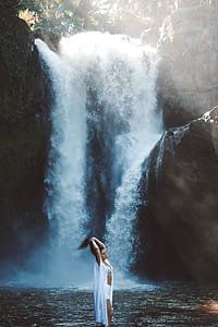 woman standing near waterfalls thumbnail
