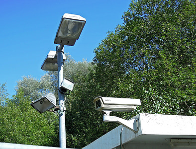 low angle photography of outdoor post lamp placed near bullet surveillance camera thumbnail