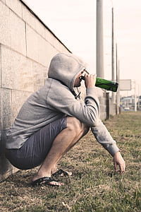 man in gray hoodie drinking bottled drink thumbnail