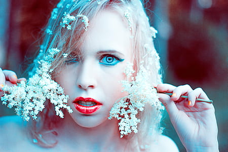 woman with red lipstick holding white petaled flowers thumbnail