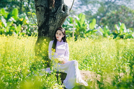 woman in purple dress sitting beside tree thumbnail
