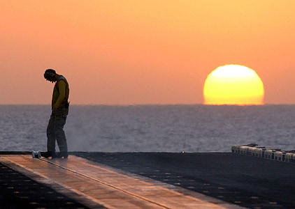 man standing beside water during golden hour thumbnail
