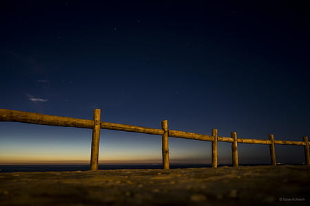 photo of brown wooden railings during night thumbnail