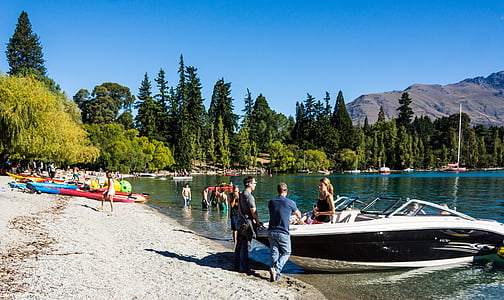 people standing near white and black powerboat on body of water thumbnail