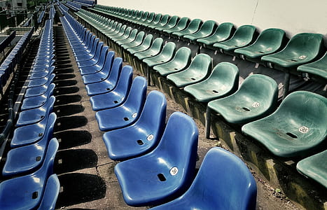blue and green stadium chair beside white wall thumbnail