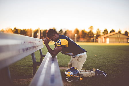 football player praying on bench thumbnail