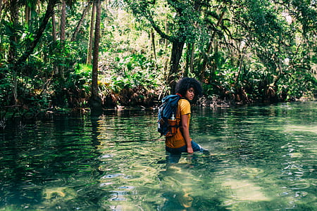 man carrying a backpack in body of water thumbnail