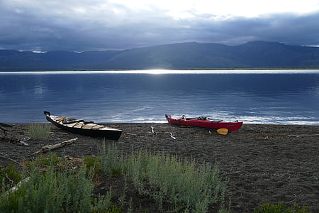 two red and black canoes on seashore thumbnail