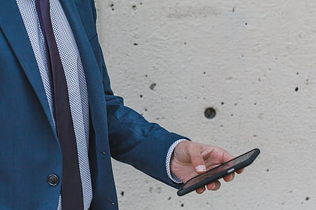 man holding black smartphone while standing thumbnail