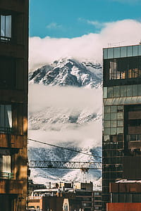mountain covered with snow near buildings thumbnail