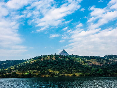 Mountain Surrounded by Green Trees in Front of Body of Water Photo thumbnail