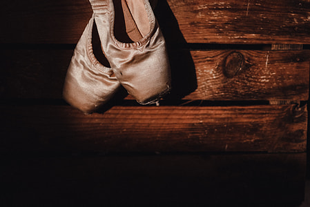 close-up photo of white ballet shoes on wooden surface thumbnail