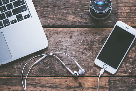 gold iPhone 6 with Apple EarPods on table thumbnail