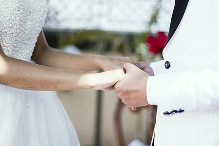 man holding woman's hand close-up photo thumbnail