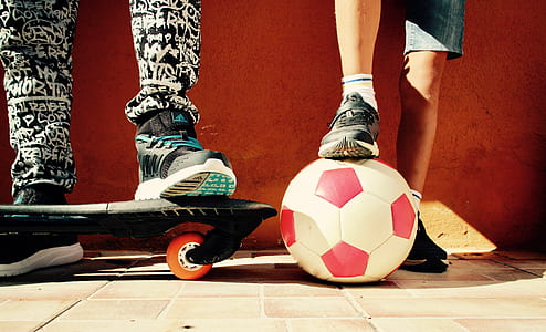 white and red soccer ball beside black skateboard thumbnail