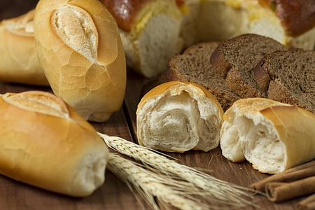 variety of bread and wheat on brown wood surface thumbnail
