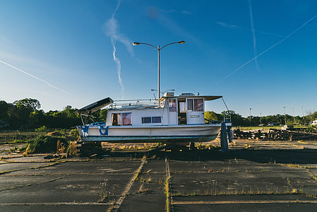 white and green boat on ground under blue sky during daytime thumbnail