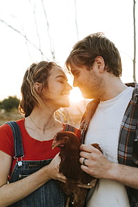Man and Woman Holding Red Chicken thumbnail