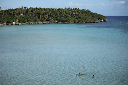 three person swimming on water during daytime thumbnail