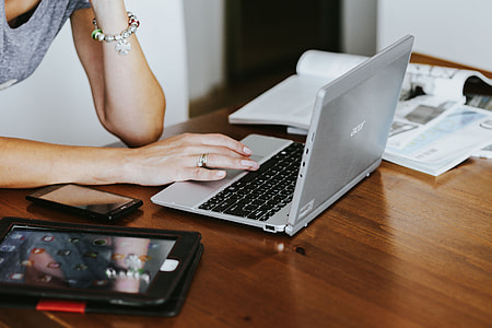 Silver laptop with various items on a table thumbnail