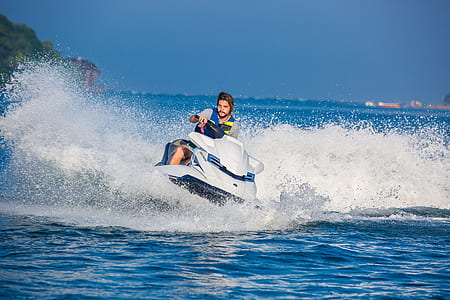 man riding on personal water craft on body of water thumbnail