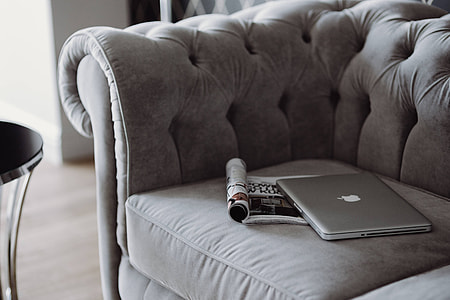 Elegant grey sofa with a laptop, an iPhone and a magazine thumbnail