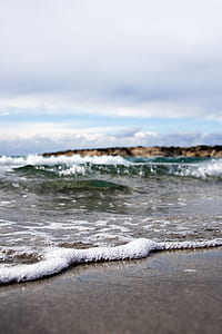 sea shore during daytime under grey clouds thumbnail