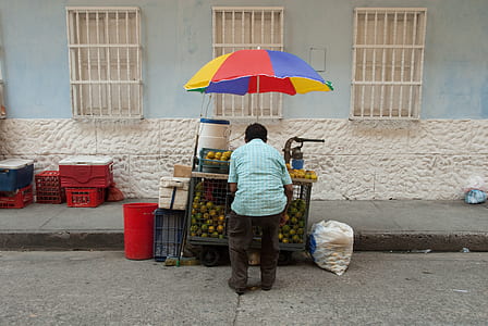 man standing near brown wooden food cart thumbnail