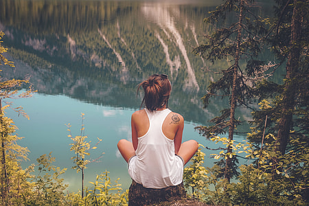 woman in white tank top sitting on cliff thumbnail