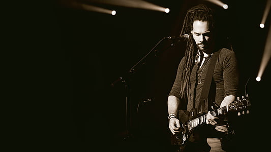 grayscale photography of man holding guitar thumbnail