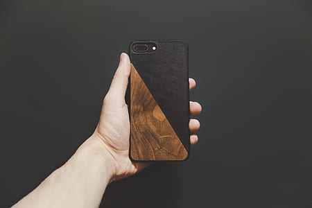 person holding phone with brown case thumbnail
