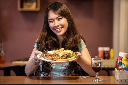 girl holding ceramic plate with food thumbnail