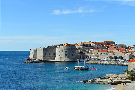 landscape photo of gray concrete castle near body of water thumbnail