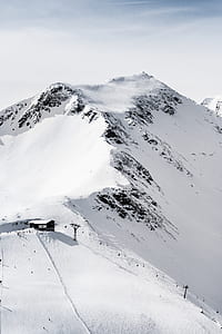 black house on top of snow covered mountain thumbnail