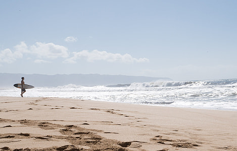 person holding surfboard on shore thumbnail