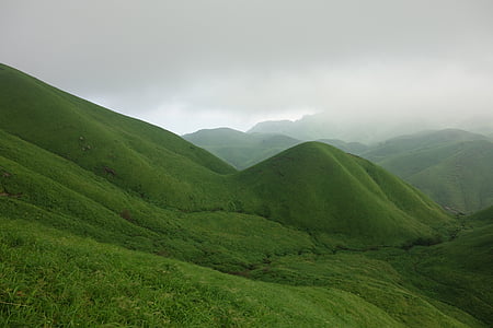 view of green hills range under gray clouds thumbnail