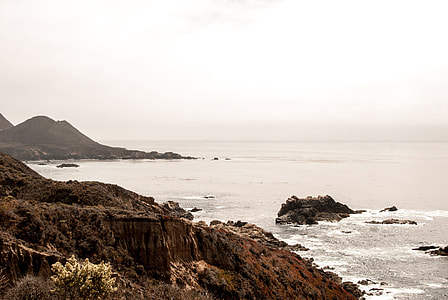 brown rock formation near ocean thumbnail