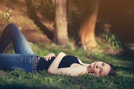 macro shot photography of woman in black strapless top lying on grass thumbnail