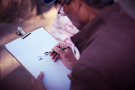 man sketching eyes on white paper thumbnail