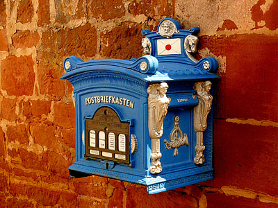 blue and brown steel mailbox attached on red concrete wall thumbnail