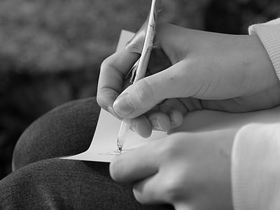 person writing on paper grayscale photo thumbnail