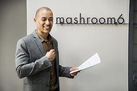 Man Wearing Grey Notched Lapel Suit Jacket Holding White Printer Paper While Standing thumbnail