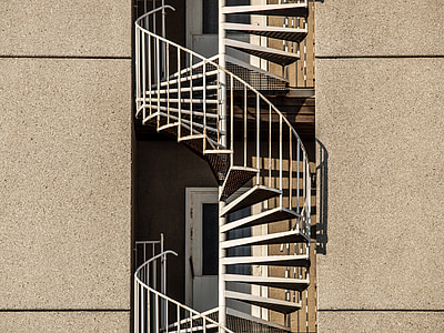 spiral stairs between concrete buildings thumbnail