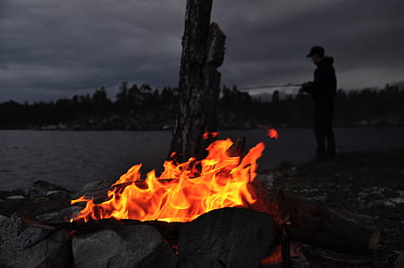 fire lit near body of water thumbnail
