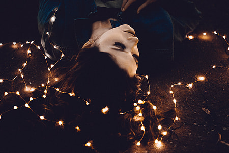 woman laying down on floor with string lights thumbnail