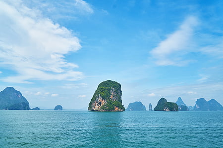green covered rock formation at the middle of sea thumbnail