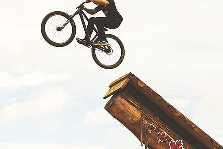 man riding black BMX bicycle doing stunt during daytime thumbnail