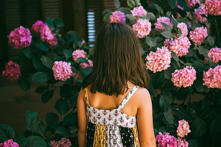 woman facing pink petaled flowers thumbnail
