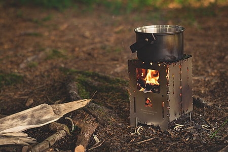 stainless steel cooing pot on burner near fire woods thumbnail